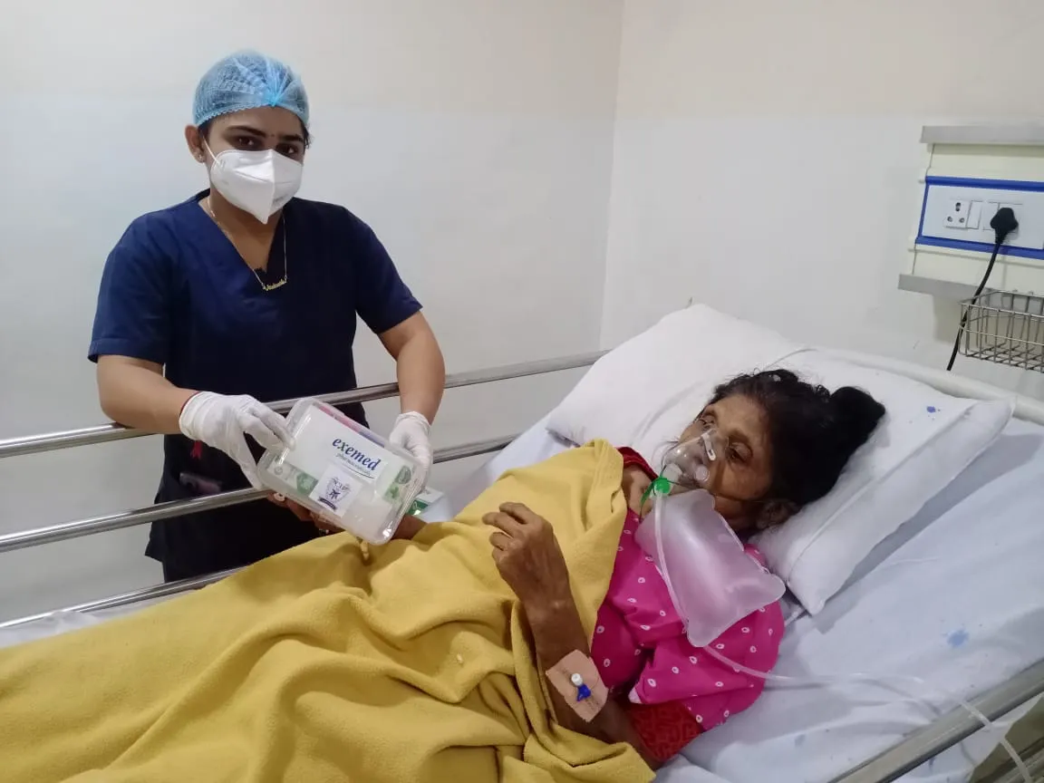 A nurse handing an Exemed medicine kit to a patient in hospital